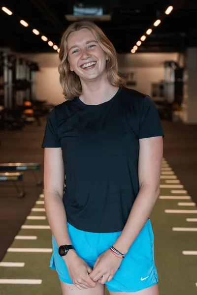 Inke standing in the gym, smiling