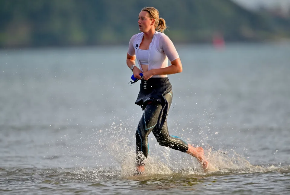 Inke mid-race, running out of the water after a triathlon swim leg